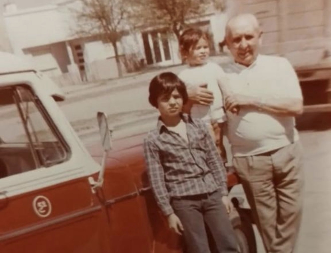 Don Barcia junto a dos chicos y una camioneta roja, foto familiar antigua